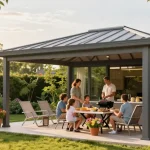 Freistehende Terrassenüberdachung mit Familie beim Grillen in Gartenatmosphäre